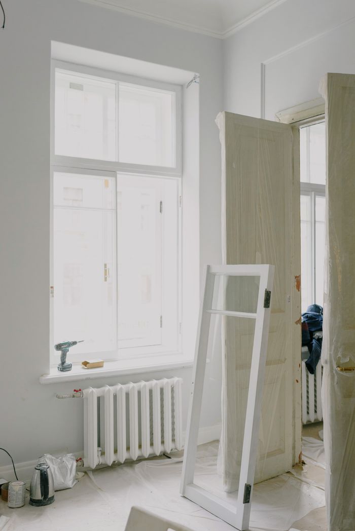 Crafting Captivating Headlines: Your awesome post title goes here Window frame on floor near wooden doors and heating system in light apartment during renovation process